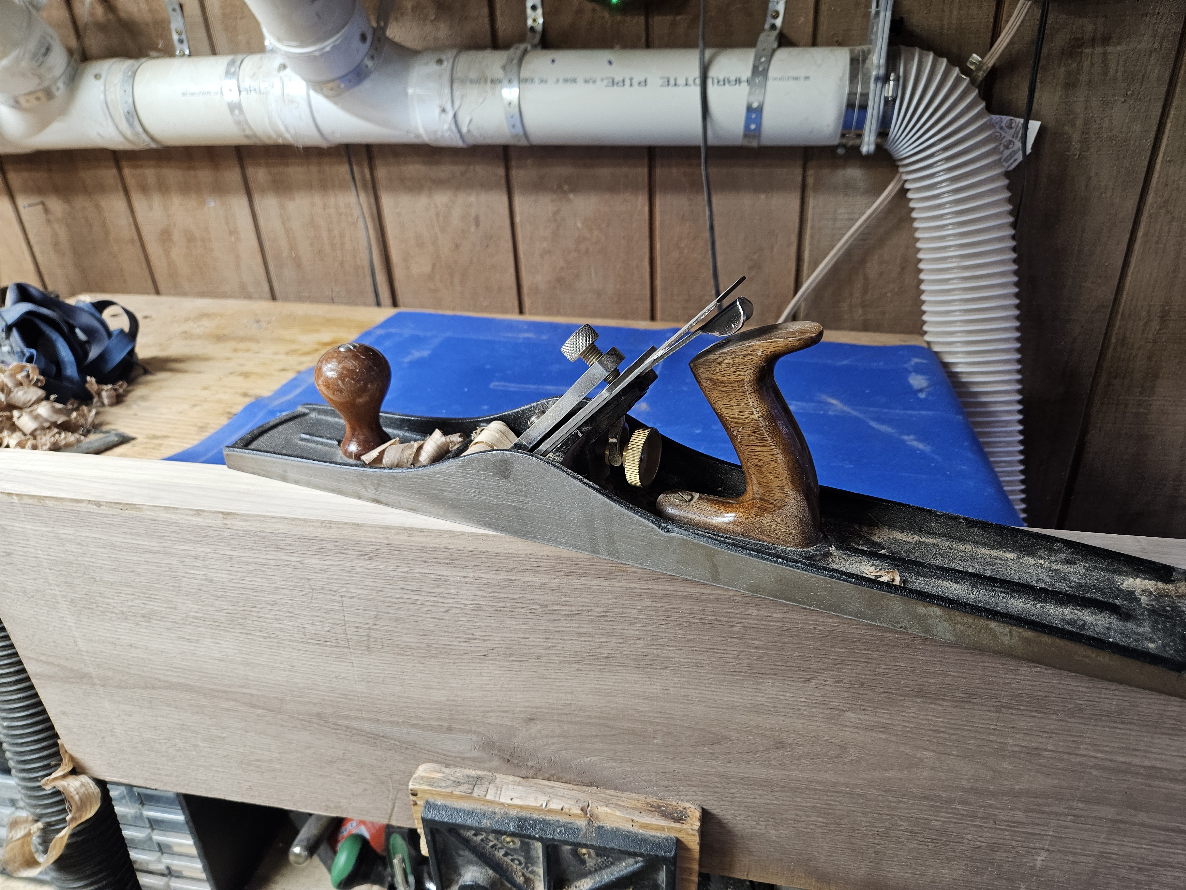 Hand plane taking a shaving off the edge of a panel